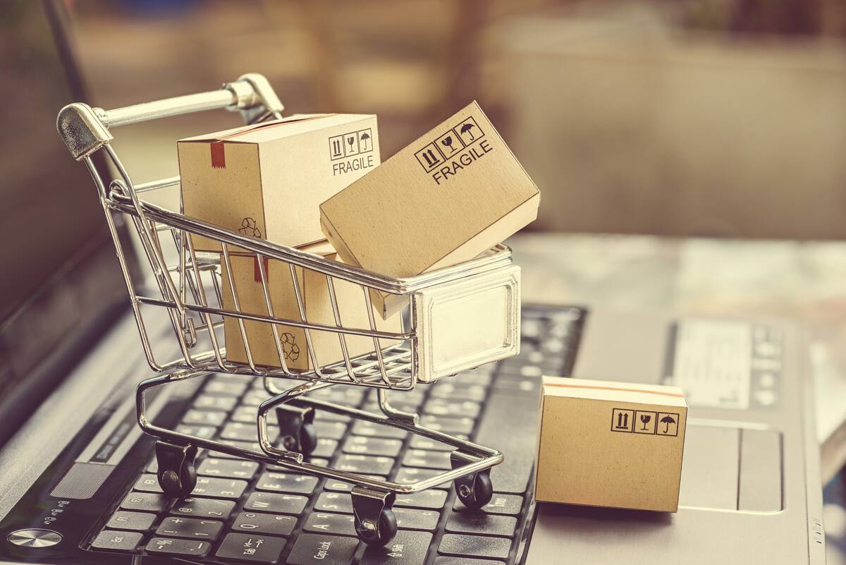 Paper boxes in a shopping cart on a laptop keyboard. Ideas about e-commerce, e-commerce or electronic commerce is a transaction of buying or selling goods or services online over the internet.