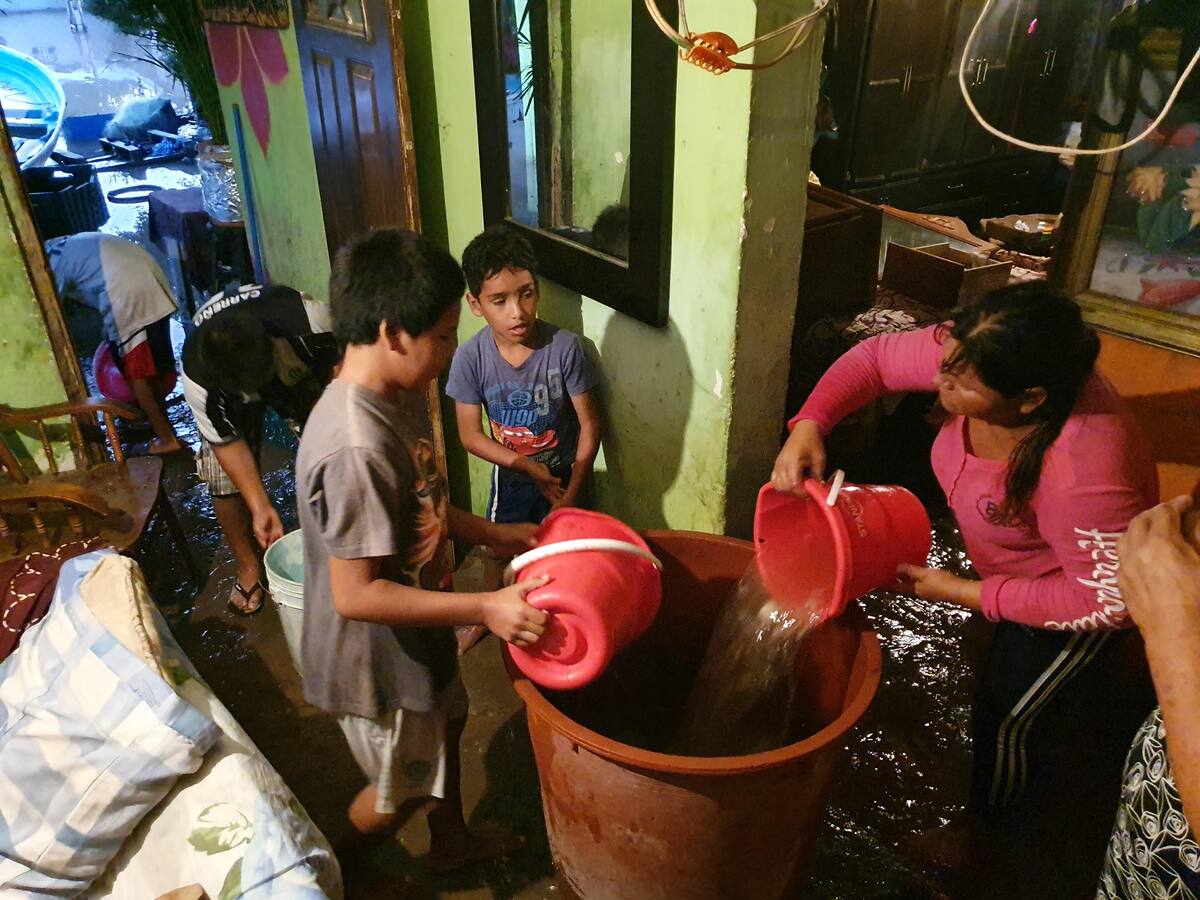Vecinos ayudaron con baldes a sacar el agua de la vivienda de María del Carmen Ruiz en el barrio de la Cruz en Kino Viejo.