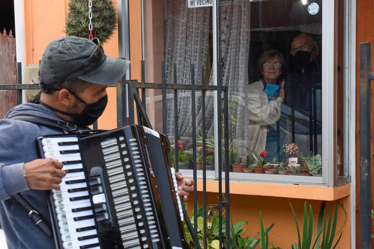 Toca el acordeón frente a la ventana de sus padres para animarlos en la cuarentena