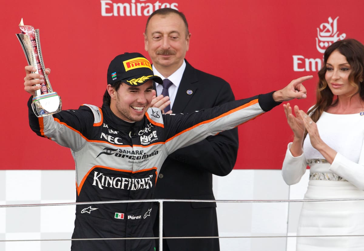 El mexicano Sergio Pérez, piloto de Force India, reacciona tras terminar en tercer lugar en el Gran Premio de Europa de Fórmula 1, disputado en el circuito de Bakú, Azerbaiyán, el domingo 19 de junio de 2016, mientras el presidente de Azerbaiyán, Ilham Aliyev, y su esposa, Mehriban Aliyeva, aplauden. (AP Photo/Ivan Sekretarev)