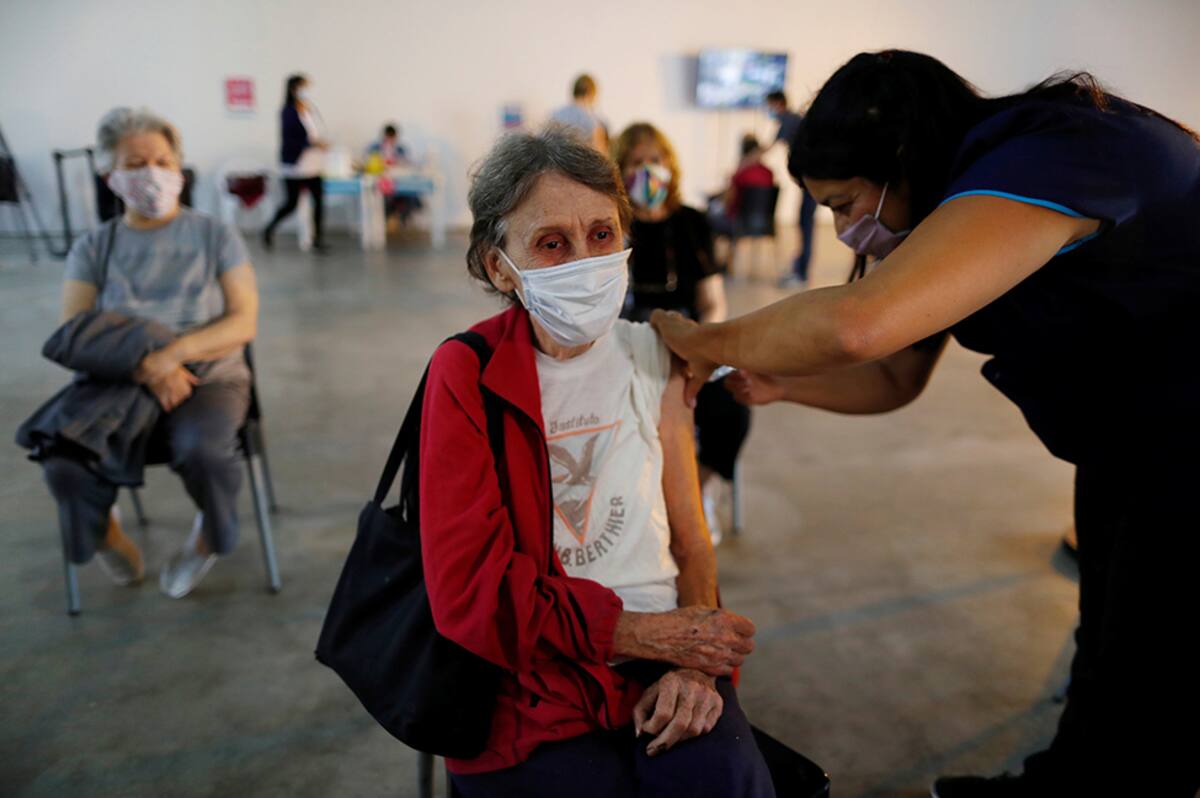 A woman receives a dose of the Sputnik V (Gam-COVID-Vac) vaccine against the coronavirus disease (COVID-19) at the Tecnopolis Park, in Buenos Aires, Argentina April 15, 2021. REUTERS/Agustin Marcarian