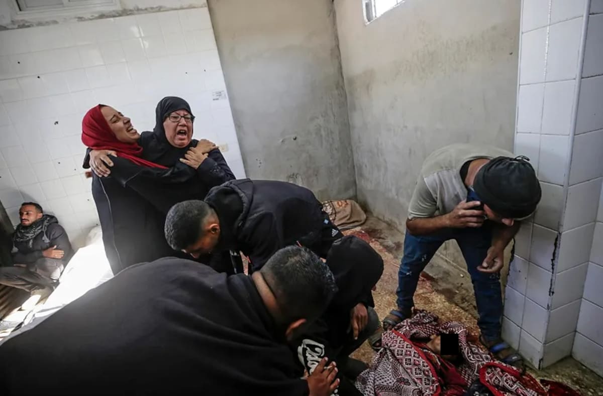 Palestinos lloran ante los cuerpos de sus familiares, muertos en un ataque aéreo israelí contra el campo de refugiados de Al Bureije en el centro de la Franja de Gaza. / EFE-EPA-Mohammed Saber