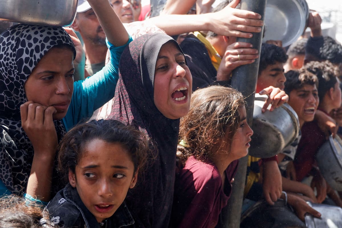 Una mujer palestina reacciona mientras personas se reúnen para recibir comida preparada por una cocina benéfica, en Jan Yunis, sur de la Franja de Gaza, el 29 de abril de 2025. REUTERS/Hatem Khaled