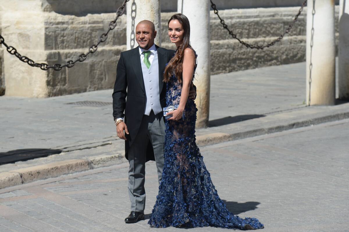 Brazilian football player Roberto Carlos and his wife Mariana Luccon arrive at the Cathedral of Seville on June 15, 2019 to attend the wedding ceremony of Real Madrid's Spanish football player Sergio Ramos and Pilar Rubio. (Photo by CRISTINA QUICLER / AFP)