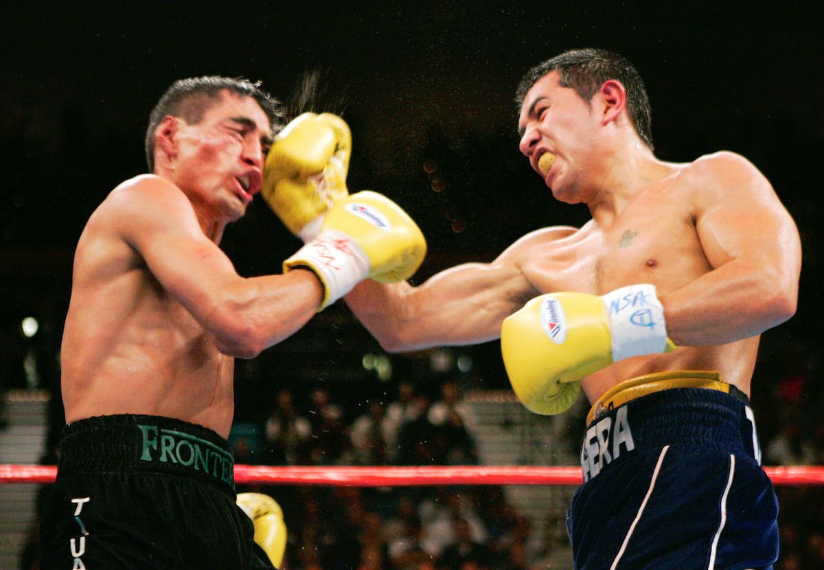 FILE - In this Nov. 27, 2004, file photo, compatriots Erik Morales, left, and Marco Antonio Barrera trade punches in the 11th round of their WBC super featherweight title fight at the MGM Grand Garden Arena in Las Vegas. Former heavyweight champion Evander Holyfield and three-division champion Marco Antonio Barrera of Mexico head a list of nine people selected for induction into the International Boxing Hall of Fame, Tuesday, Dec. 6, 2016.(AP Photo/Mark J. Terrill, File)