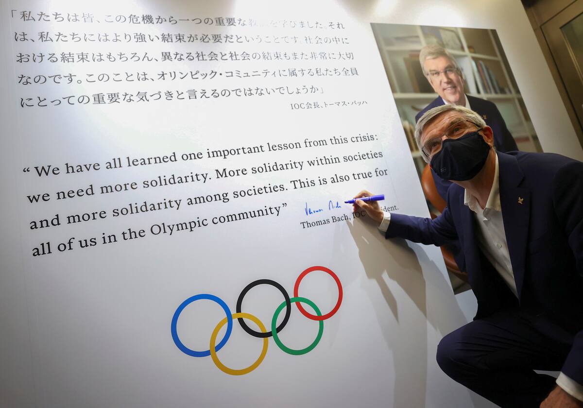 Foto del viernes del presidente del COI, Thomas Bach, autografiando un mural en una exhibición sobre la historia de los Juegos en Tokio. Jul 30, 2021. REUTERS/Issei Kato/Pool