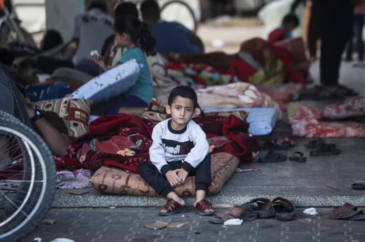 Un niño está sentado sobre un colchón en el patio, que sirve como refugio para los desplazados en el Estado de Palestina.
/ UNICEF
