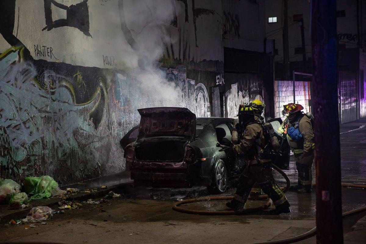 Bomberos evitaron que el fuego alcanzara otros vehículos estacionados cerca de la calle Quinta durante la madrugada de este martes. Foto: Border Zoom