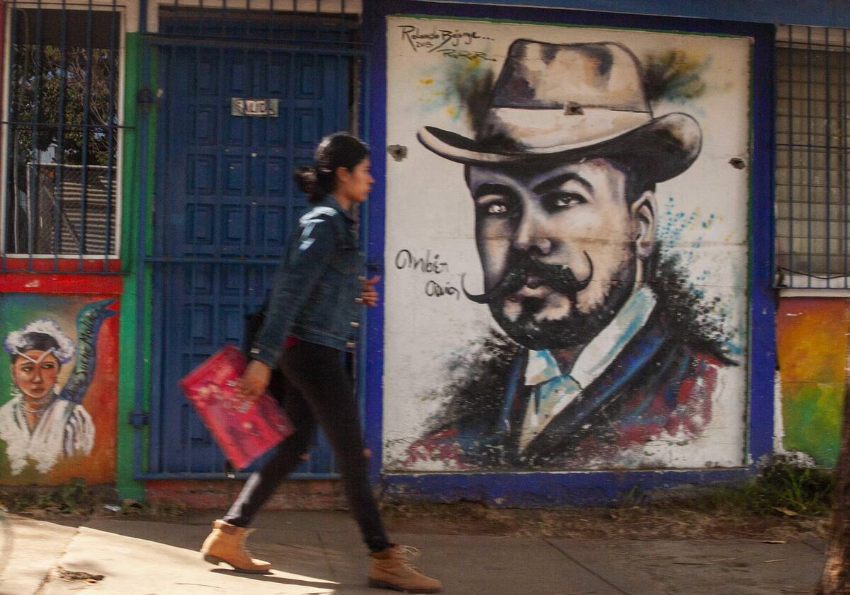 Una mujer camina junto a un mural en honor al poeta Rubén Darío