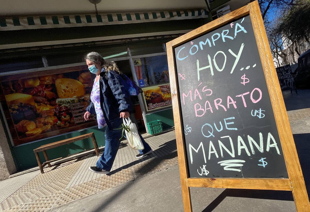 Foto de archivo. Un comprador pasa frente a un cartel que dice "Compre hoy, más barato que mañana"que refleja la elevada inflación que golpea al país austral, en Buenos Aires, Argentina, el 29 de julio de 2022. REUTERS/Agustin Marcarian