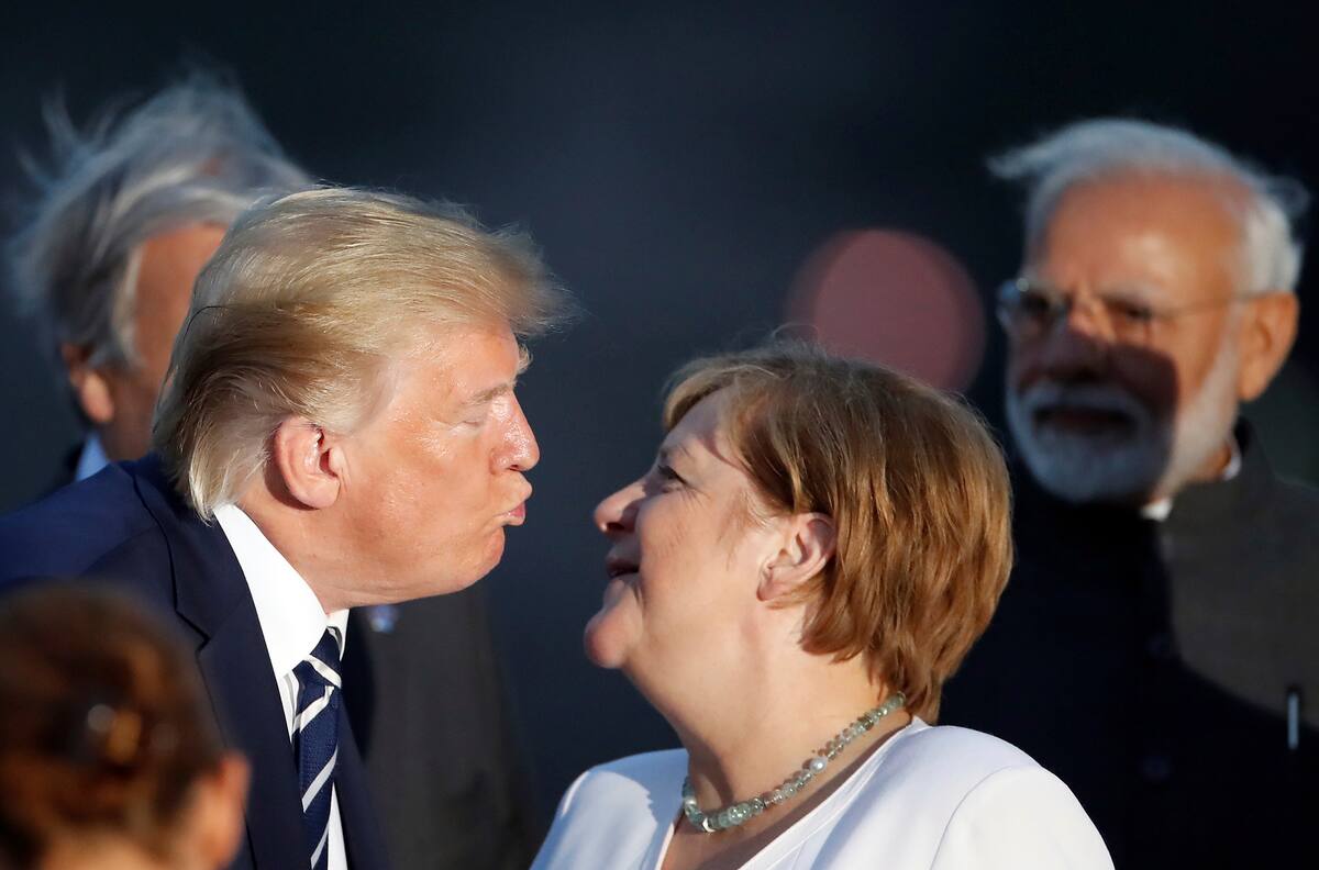 El presidente estadounidense Donald Trump besa a la canciller alemana Angela Merkel durante la Cumbre del Grupo de los Siete, el domingo 25 de agosto de 2019, Biarritz, Francia. (Christian Hartmann, Pool vía AP)