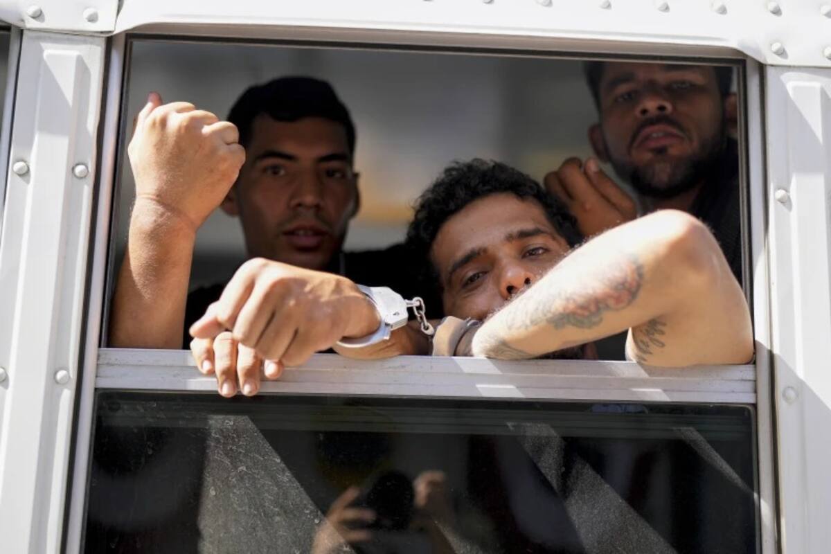 Migrantes colombianos miran desde un autobús panameño que los transporta desde un centro de recepción de migrantes en Lajas Blancas, adonde llegaron tras cruzar el Tapón del Darién rumbo a la frontera sur de Estados Unidos, hasta una estación de policía en la Ciudad de Panamá, el 11 de marzo de 2025. | Crédito: AP/Matias Delacroix