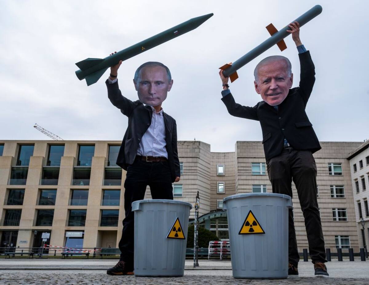 Peace activists wearing masks of Russian President Vladimir Putin (L) and newly elected US President Joe Biden pose with mock nuclear missiles in front of the US embassy in Berlin on January 29, 2021 in an action to call for more progress in nuclear disarmament. - The Russian parliament on January 27, 2021 unanimously voted to ratify an agreement to extend by five years a key nuclear pact with the United States that was set to expire soon. Signed in 2010, the New START contract caps to 1,550 the number of nuclear warheads that can be deployed by Moscow and Washington, which control the world's largest nuclear arsenals. The agreement, which was due to expire on February 5, is seen as a rare opportunity for compromise between Moscow and Washington, whose ties have dramatically deteriorated in recent years. (Photo by John MACDOUGALL / AFP) (Photo by JOHN MACDOUGALL/AFP via Getty Images)
