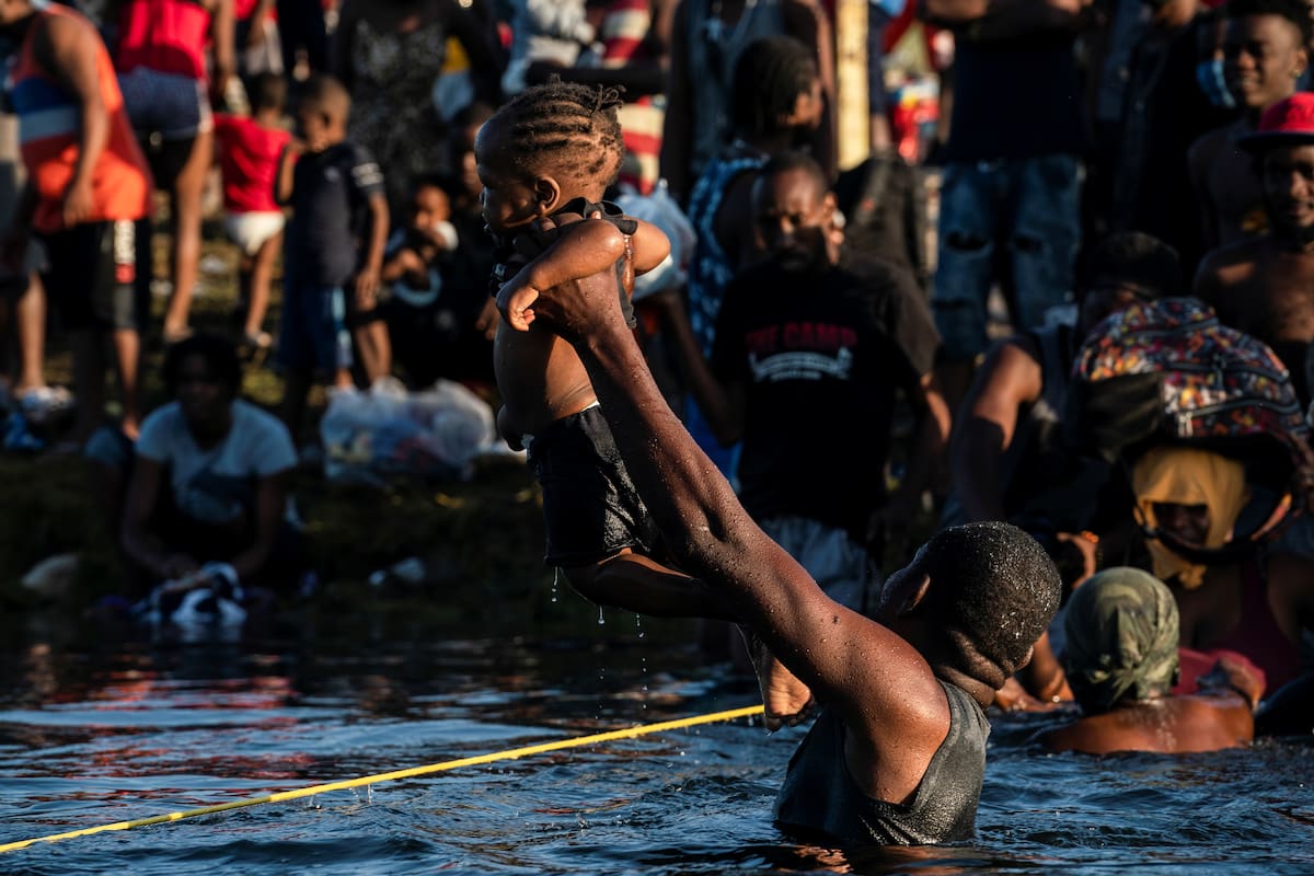 Un migrante que busca asilo en Estados Unidos sostiene a un niño mientras cruza el río Grande hacia México cerca del Puente Internacional entre ambas naciones en Ciudad Acuña, México. el 20 de septiembre de 2021. REUTERS / Go Nakamura