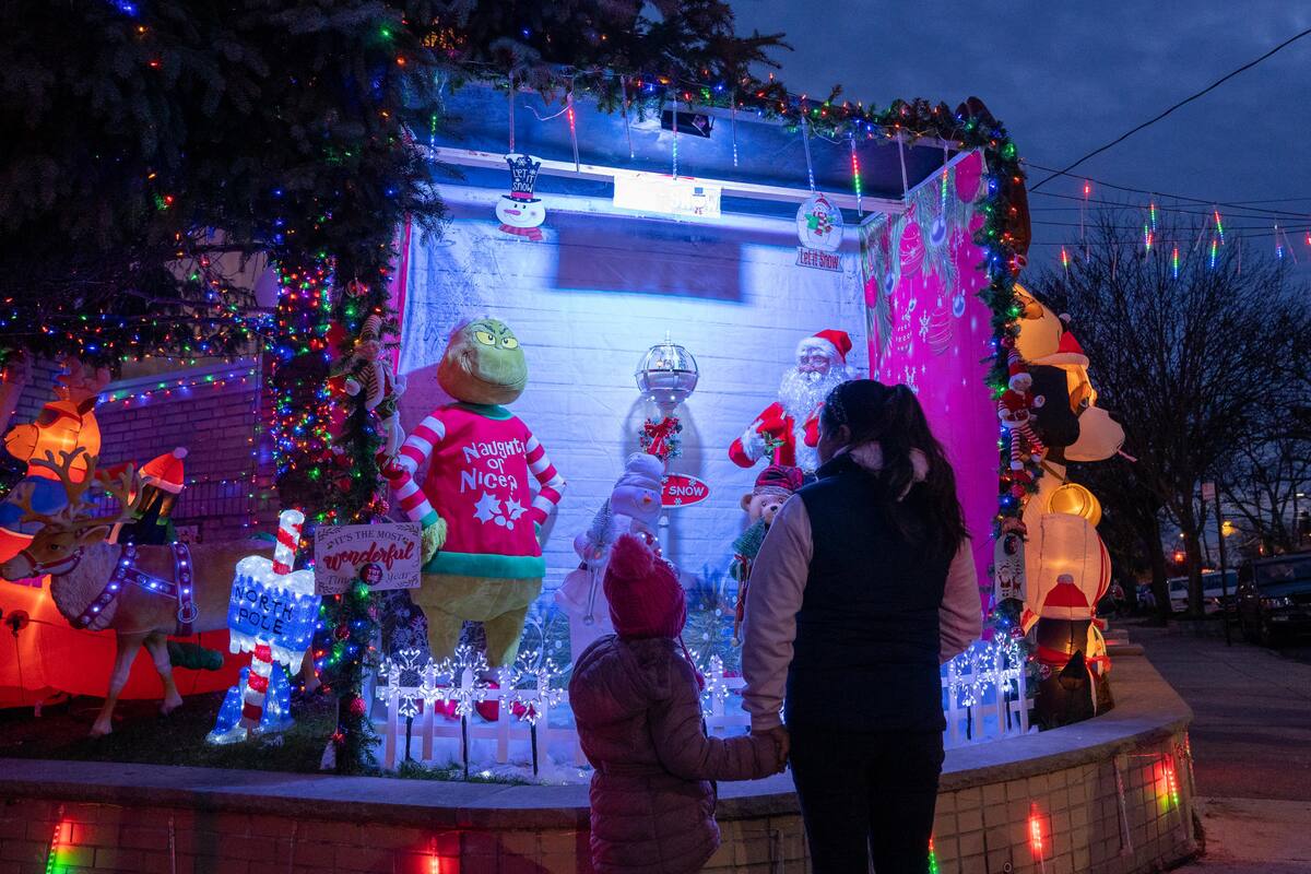 Personas visitan decoraciones navideñas puestas en las entradas de casas, el 8 de diciembre de 2022 en el barrio residencial de Dyker Heights, al sur de Brooklyn, Nueva York (EE. UU). EFE/Ángel Colmenares