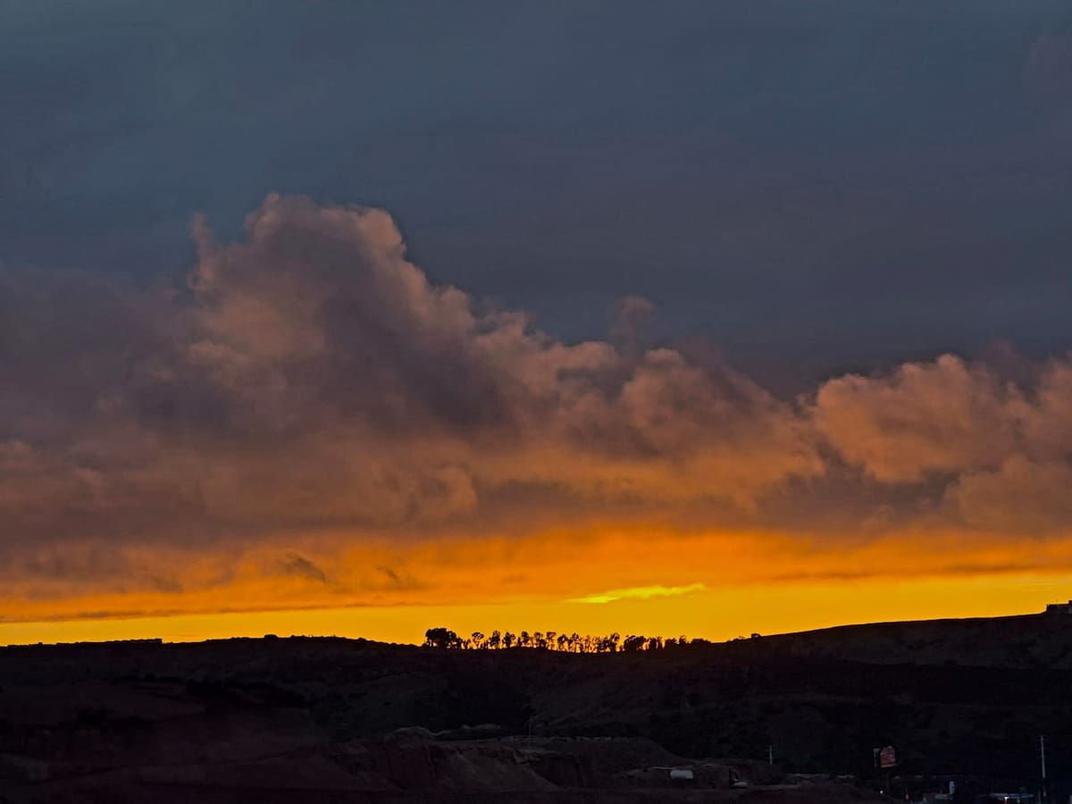 Remanentes con nubes densas en tonos grises plomizos se desplazaron hacia la costa del Pacífico, mientras una franja de luz en matices naranjas proyectó calidez visual. Foto: Sergio Ortiz
