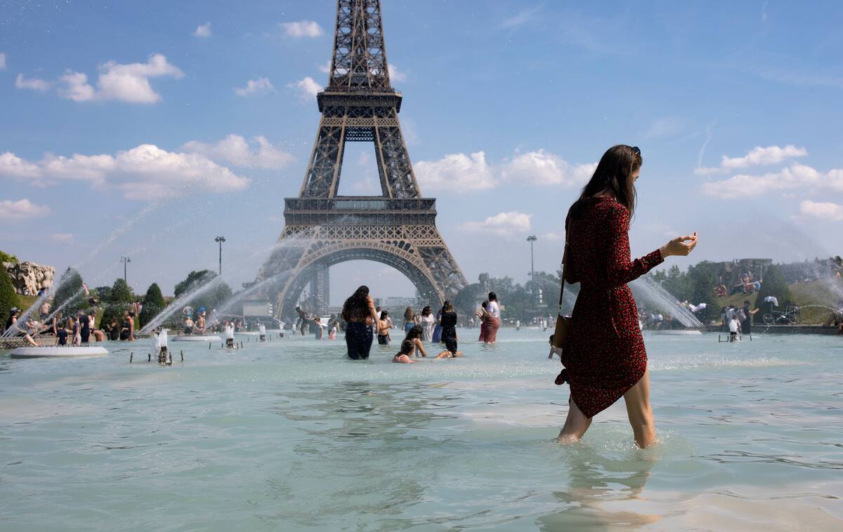 IAN53. PARÍS (FRANCIA), 25/06/2019.- Una mujer se refresca con el agua de la fuente de la Plaza del Trocadero, frente a la Torre Eiffel, durante la ola de calor que recorre París este martes (Francia). Las temperaturas llegarán a los 40 grados centígrados esta semana. EFE/Ian Langsdon