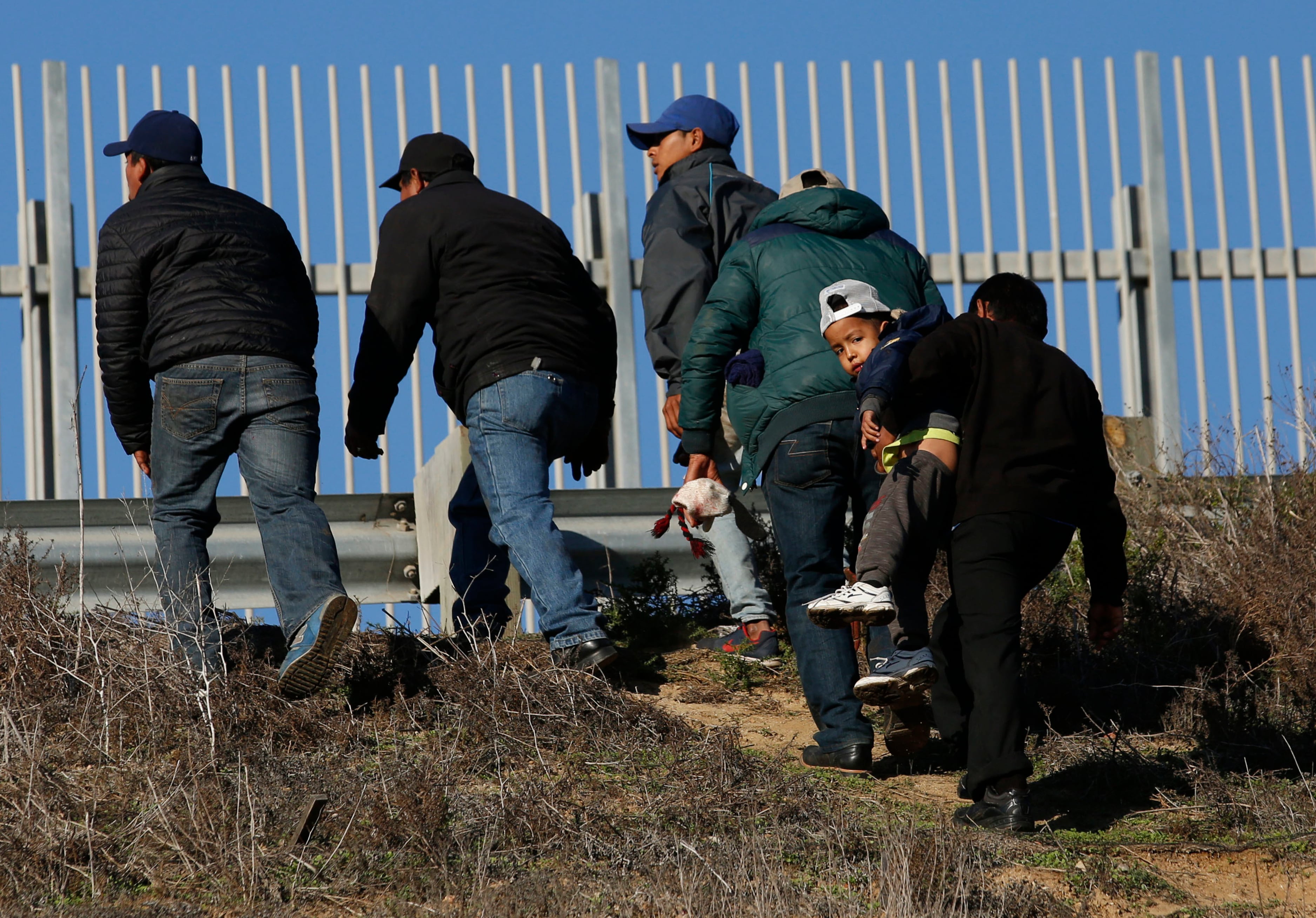 ARCHIVO - En esta fotografía de archivo del 12 de diciembre de 2018, migrantes hondureños, uno de ellos cargando a un niño, se dirigen de Tijuana, México, a la frontera con Estados Unidos para entregarse a agentes de la Patrulla Fronteriza. (AP Foto/Moises Castillo, Archivo)