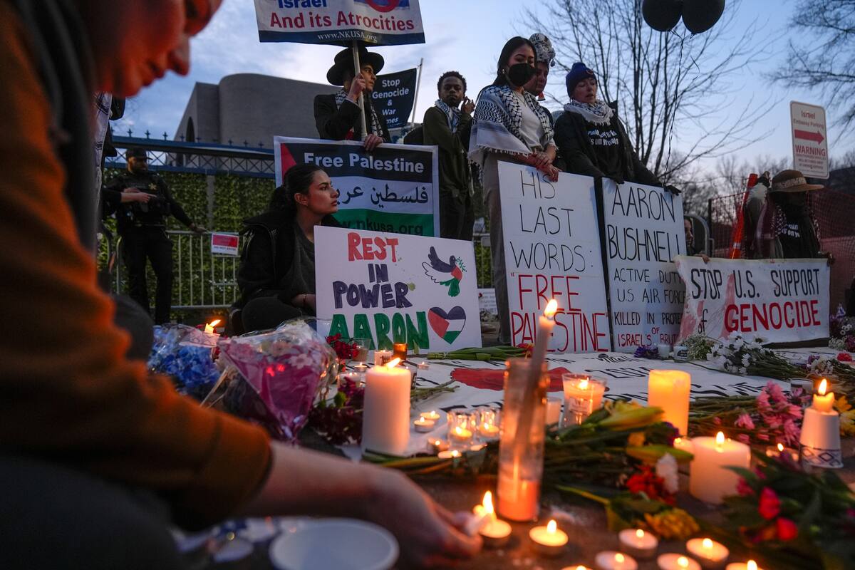 Personas encienden veladoras durante una vigilia para conmemorar al aviador Aaron Bushnell afuera de la embajada israelí en Washington el lunes 26 de febrero de 2024. Bushnell murió a causa de las heridas que sufrió tras prenderse fuego afuera de la embajada. (AP Foto/Mark Schiefelbein)