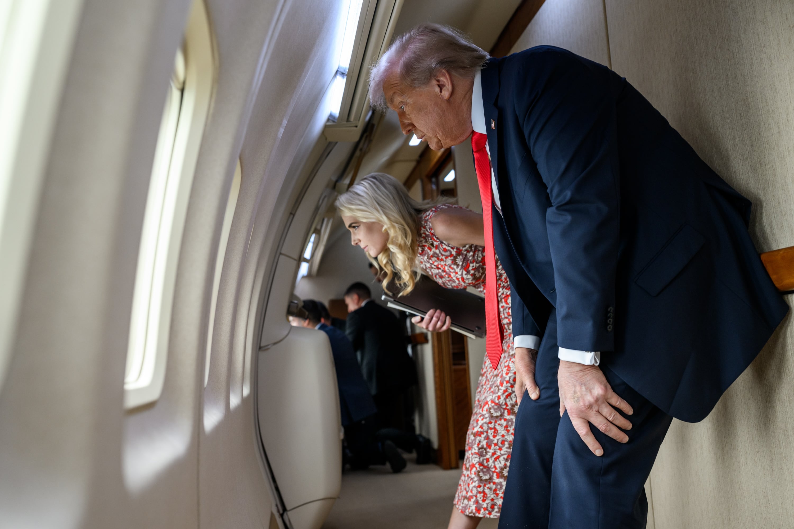 Donald Trump, acompañado por su asesora Natalie Harp, observa por una de las ventanillas del Air Force One antes de aterrizar en el Aeropuerto LaGuardia, en Nueva York, el 7 de septiembre de 2025, para asistir a la final masculina del US Open. | Crédito: Daniel Torok / Casa Blanca, vía Wikimedia Commons.