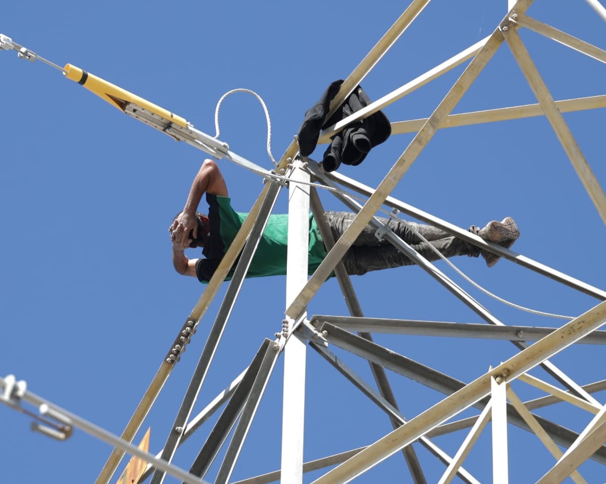 Un hombre reposa acostado en la parte más alta de una torre de alta tensión de la CFE, quien movilizó a cuerpos de emergencia. Tras un operativo lograron bajarlo sano y salvo. Foto: Javier Gallegos