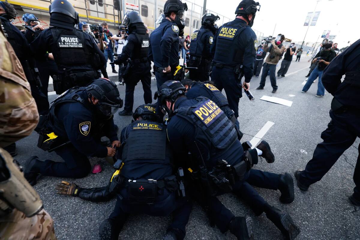 Police detain a protestor near the Metropolitan Detention Center in downtown Los Angeles during a “No Kings” protest Saturday, March 28, 2026. (AP Photo/Jill Connelly)