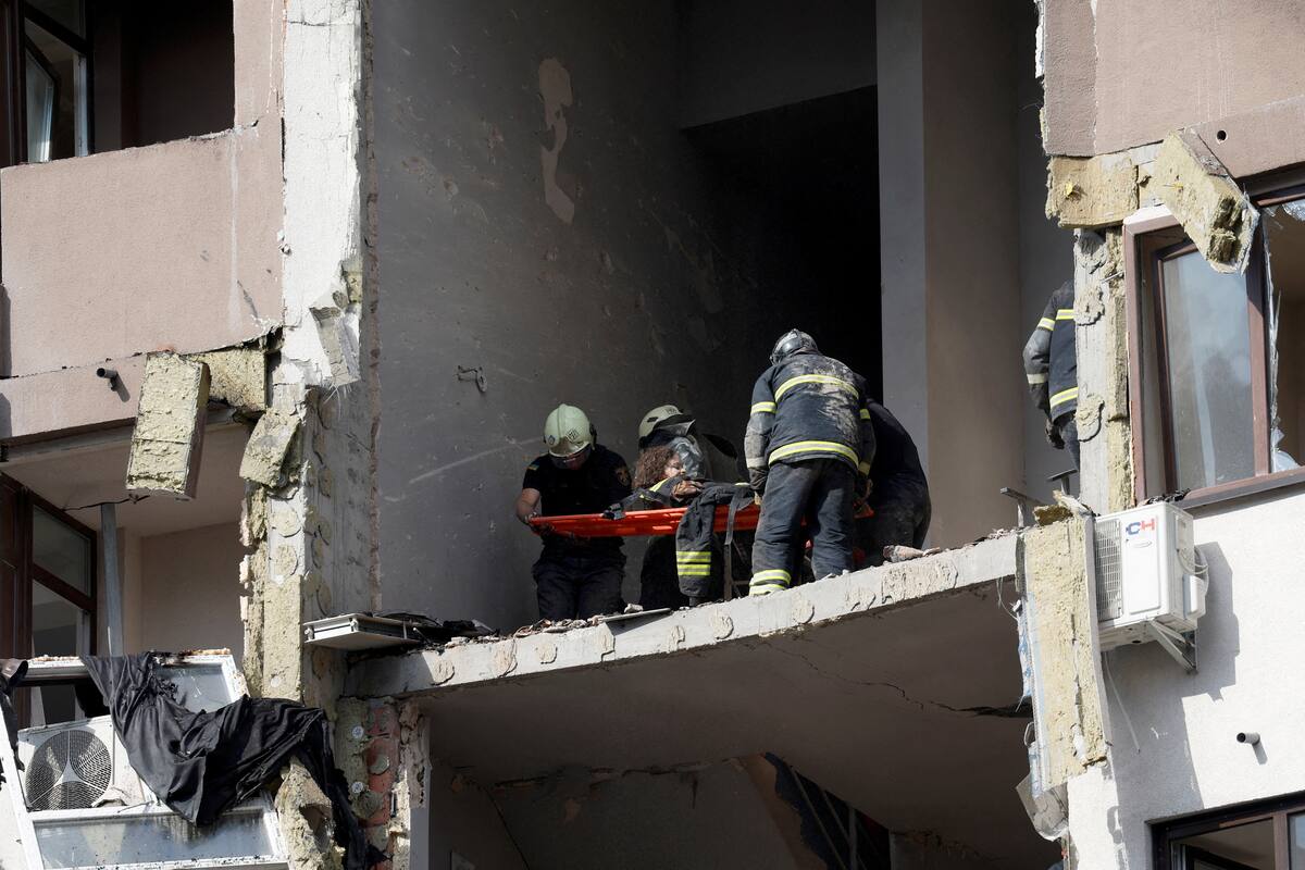 Rescue workers evacuate a person from a residential building damaged by a Russian missile strike, as Russia's attack on Ukraine continues, in Kyiv, Ukraine June 26, 2022. REUTERS/Valentyn Ogirenko