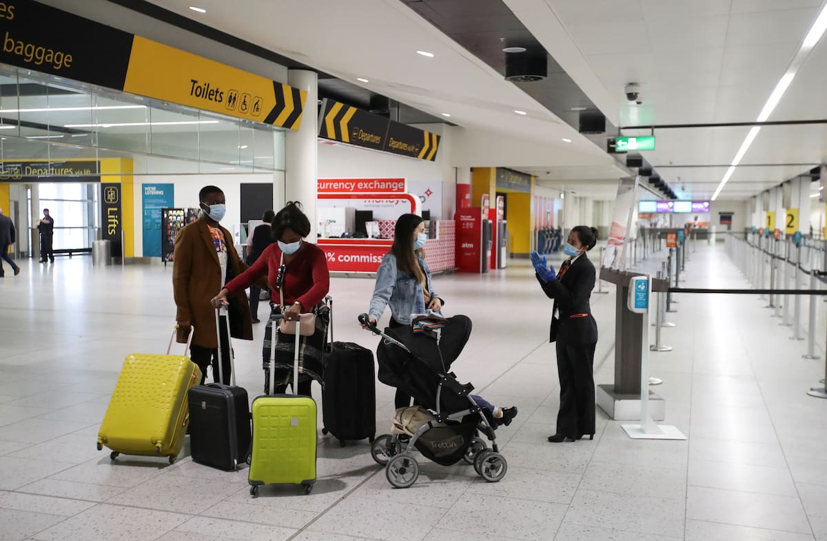 Passengers wearing face masks wait in front of the check-in counters at Gatwick Airport, amid the coronavirus disease (COVID-19) outbreak, in Gatwick, Britain June 15, 2020. REUTERS/Peter Cziborra