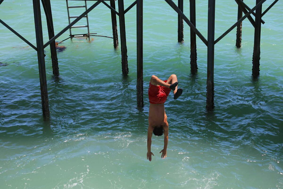 Jóvenes clavadistas aprovecharon para complacer con sus acrobacias a vacacionistas en el muelle, a pesar de que está prohibido hacerlo.
