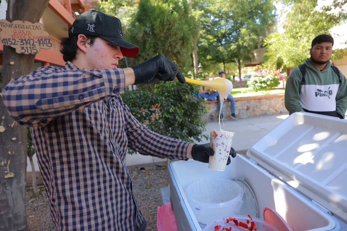 Yahir Antonio Avilés Ramírez instala su carrito bajo un árbol al lado del edificio de la carrera de Negocios y Comercio Internacional de la Unison. | Crédito: Julio A. Clark