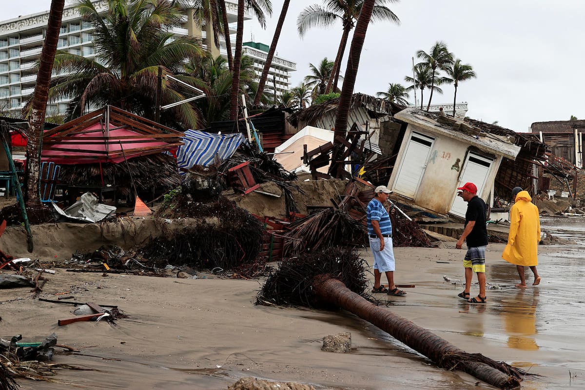 MEX5396. ACAPULCO (MÉXICO), 14/06/2025.- Personas observan los estragos causados por el fuerte oleaje e intensas lluvias, este sábado en Acapulco (México). La tormenta tropical Dalila ha dejado daños en la infraestructura del puerto mexicano de Acapulco, estado de Guerrero (sur), como restaurantes y techos de edificios colapsados, árboles caídos, calles inundadas y deslaves en avenidas principales, tras su avance con intensas lluvias por el Pacífico mexicano. EFE/ David Guzmán