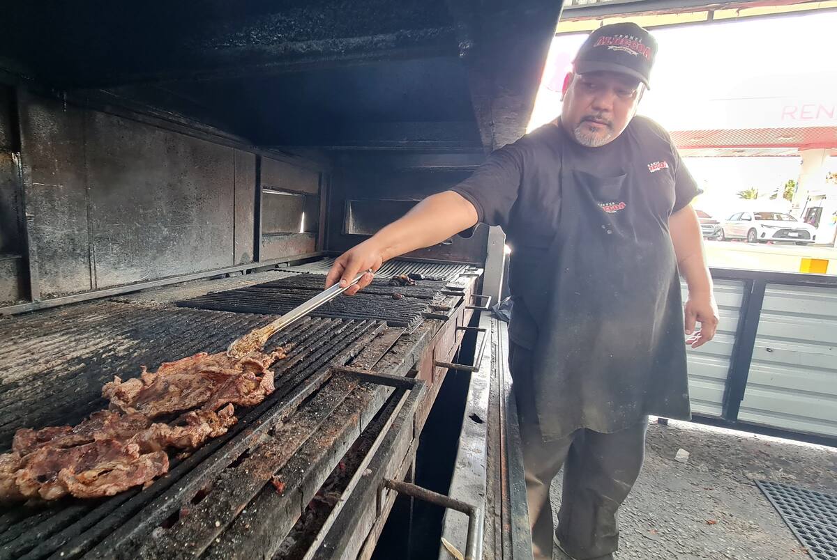 Juan Fernando Cruz asa la carne en un comercio de la colonia Villa de Seris. FOTO: JULIÁN ORTEGA