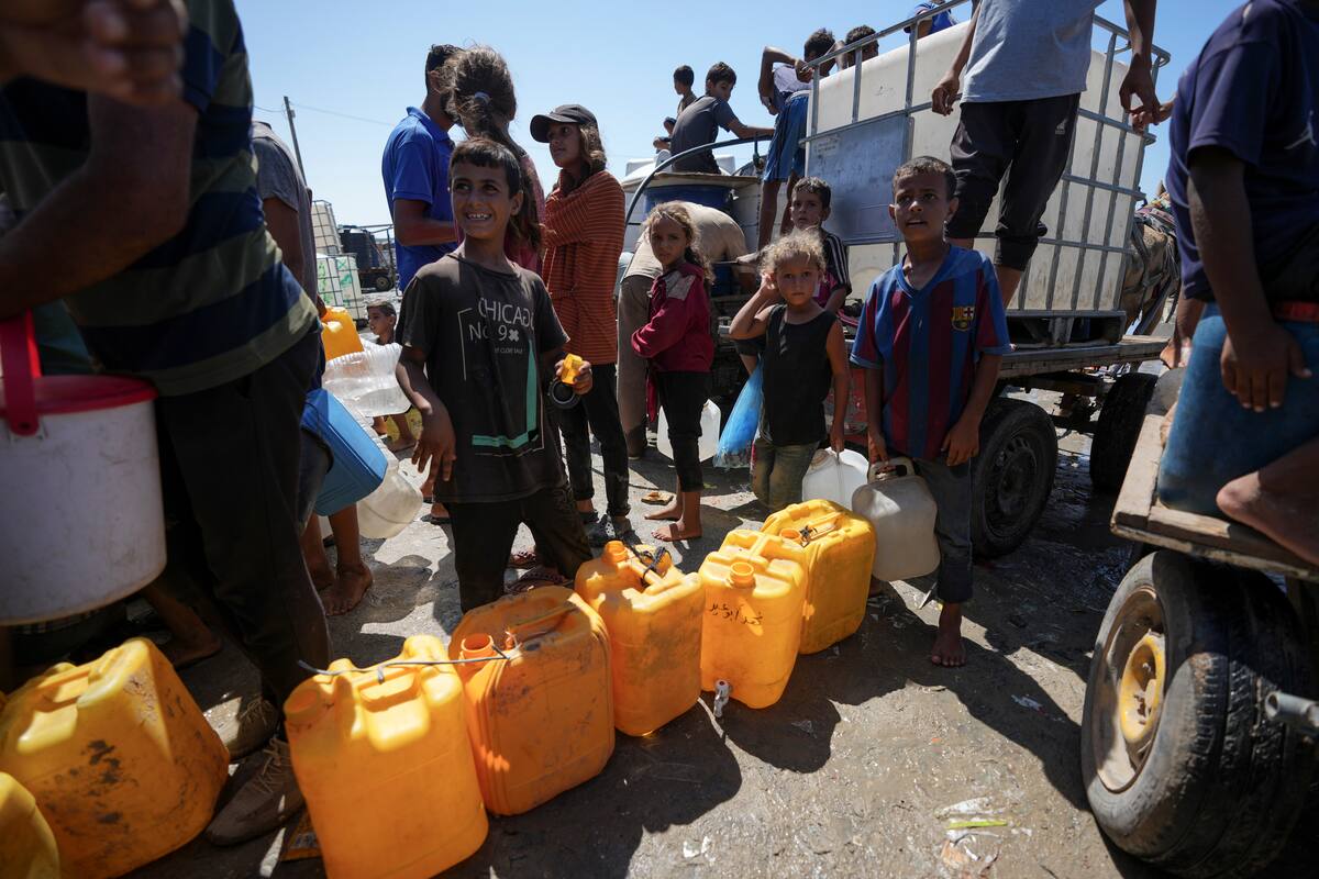 Palestinos desplazados hacen fila para obtener agua, en Deir al Balah, en la Franja de Gaza, el viernes 23 de agosto de 2024. (AP Foto/Abdel Kareem Hana)