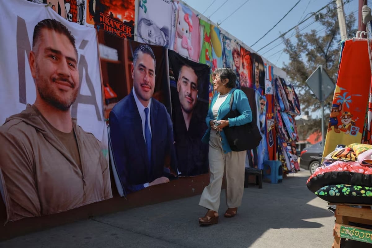 Una mujer observa la mercancía en puestos callejeros que venden mantas con la imagen del ministro de Seguridad de México, Omar García Harfuch, de 44 años, cuya popularidad se disparó tras la muerte del líder del cártel, El Mencho, en una acera de Ecatepec, Estado de México, México, 12 de marzo de 2026. REUTERS/Henry Romero.