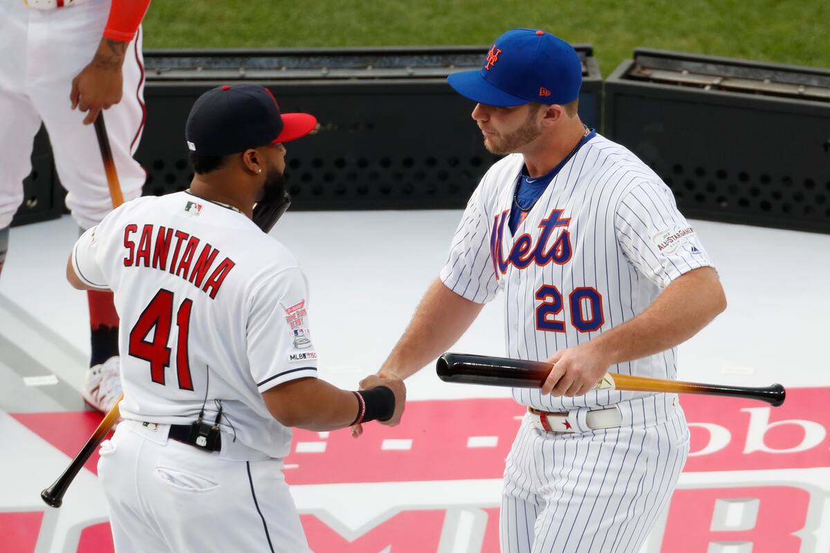 El dominicano Carlos Santana, de los Indios de Cleveland, y Pete Alonso, de los Mets de Nueva York, se dan la mano antes del Derby de Jonrones, el lunes 8 de julio de 2019, en Cleveland (AP Photo/Ron Schwane)