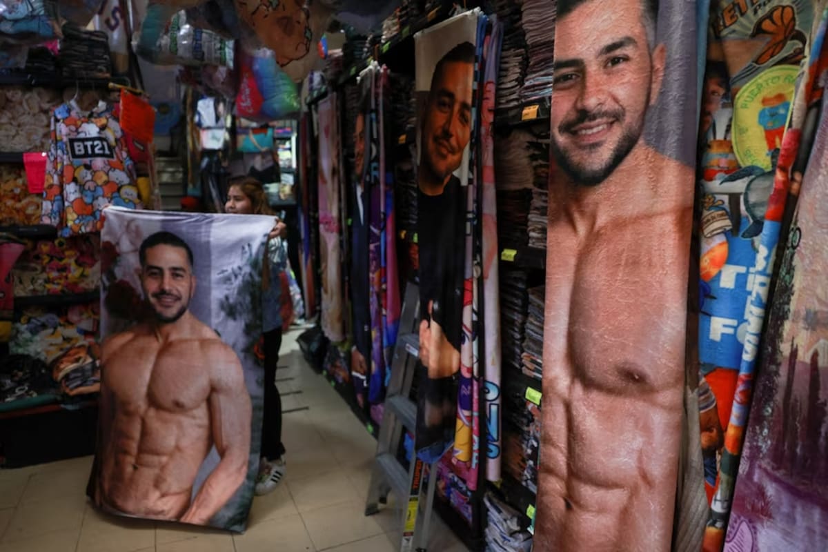 Ingrid Rebeca Sánchez, de 22 años, diseñadora de productos con la imagen del ministro de Seguridad de México, Omar García Harfuch, de 44 años, cuya popularidad aumentó tras la muerte del líder del cártel El Mencho, muestra una manta a la venta en una tienda de la Ciudad de México, México, el 12 de marzo de 2026. REUTERS/Henry Romero.