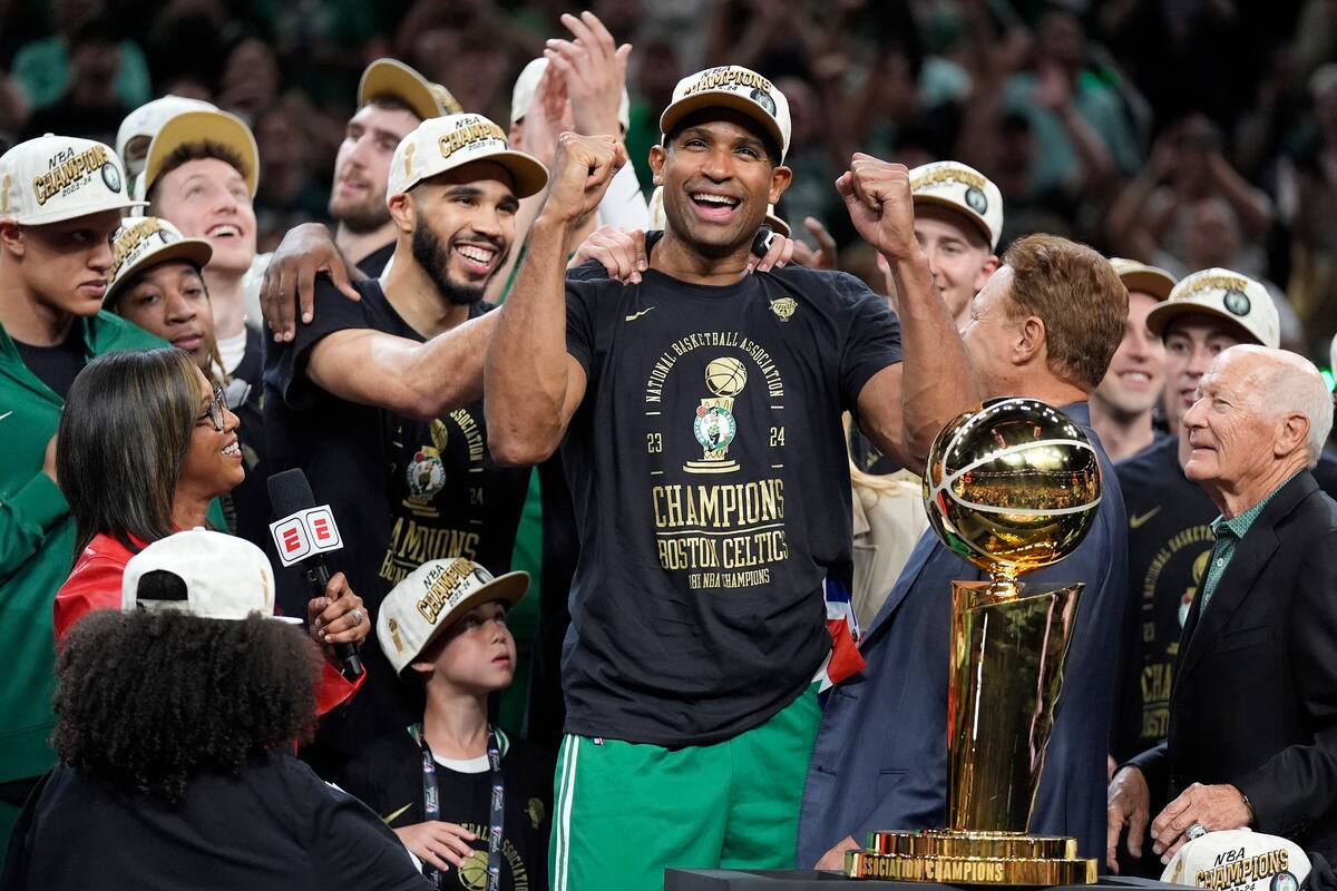 Al Horford (centro) y Jayson Tatum de los Celtics de Boston celebran tras consagrarse campeones de la NBA al vencer a los Mavericks de Dallas, el lunes 17 de junio de 2024, en Boston. (AP Foto/Charles Krupa)