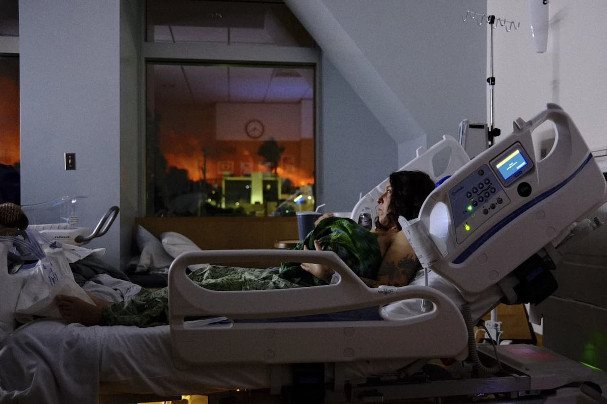 Ariel Hart sostiene a su bebé recién nacido mientras las llamas del incendio de Palisades son visibles a través de la ventana en el hospital St. John en Santa Monica, California, el martes 7 de enero de 2025. | Crédito: Jordan Hart, vía AP