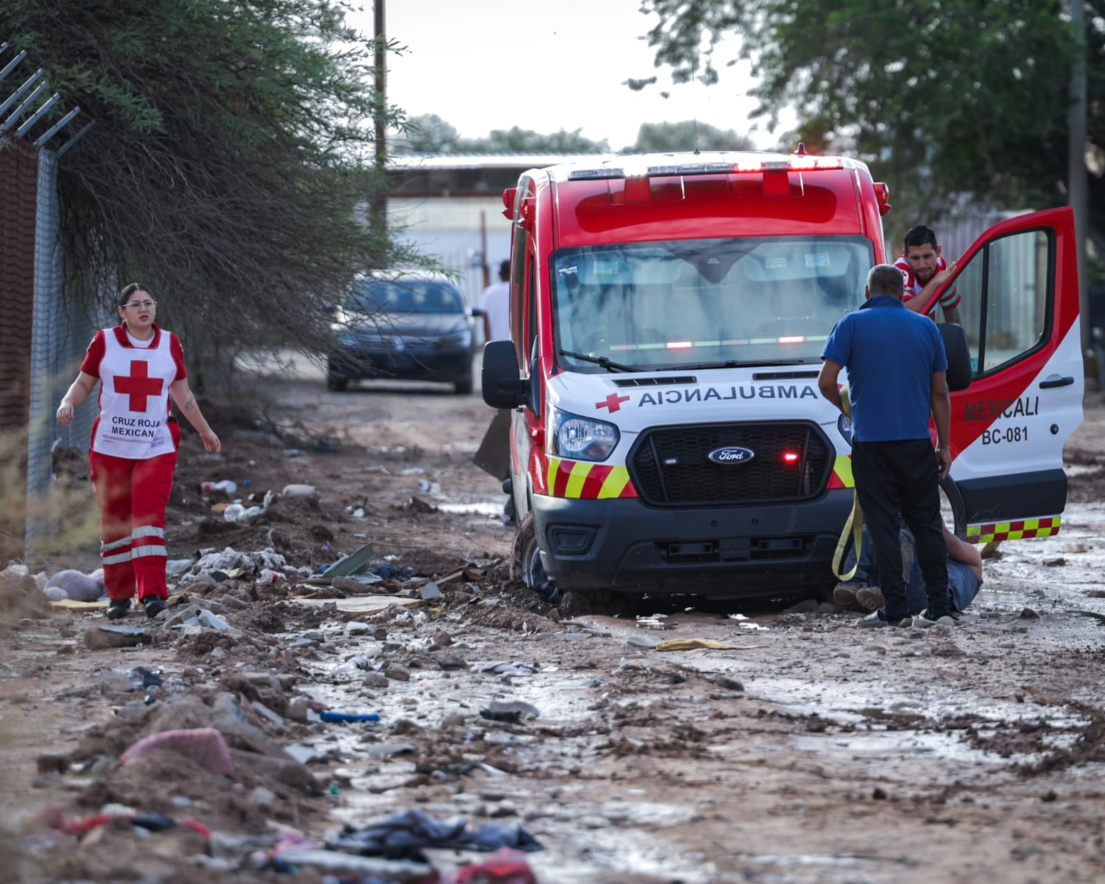 Ciudadanos ayudaron a liberar una ambulancia de la Cruz Roja que quedó atascada en el lodo cuando acudía a atender una emergencia en la colonia El Paraíso. Foto: Javier Gallegos.