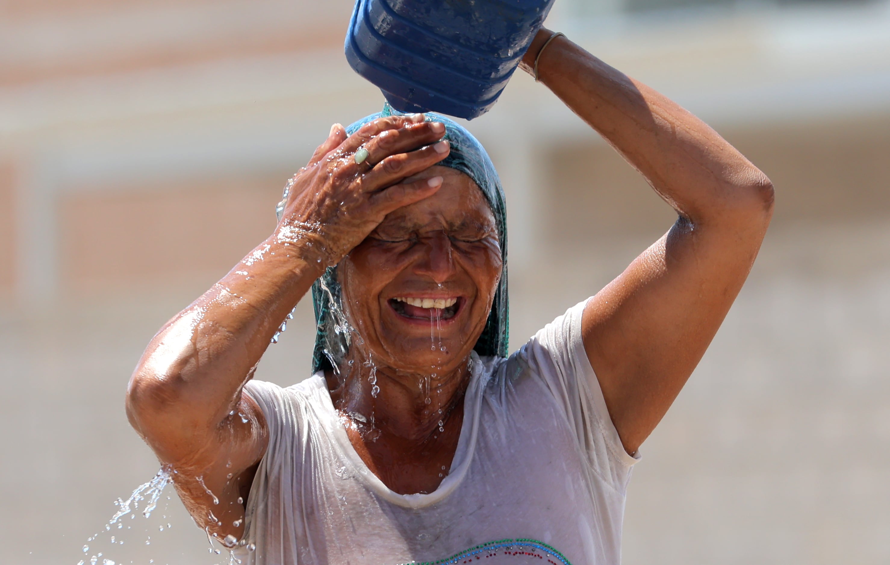 Una mujer se refresca vaciando agua encima ante el intenso calor en Hermosillo. | Julián Ortega