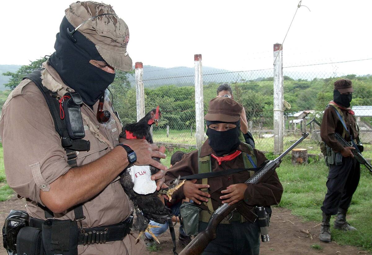 MEX14 CHIAPAS (MÉXICO), 06/08/05. El líder de los rebeldes zapatistas de México, el "Subcomandante Marcos" (i), sostiene un gallo de pelea durante su reaparición hoy en público tras cinco años de ausencia y acusó de "traición" al aspirante presidencial de la izquierda, Andrés López Obrador. Luciendo un pasamontañas y escoltado por cinco personas, "Marcos" apareció en la selvática aldea de San Rafael, en el estado de Chiapas (sur), para discutir una "amplia" plataforma política con delegados de organizaciones no gubernamentales, campesinas y sindicales. EFE/Pablo Virgen