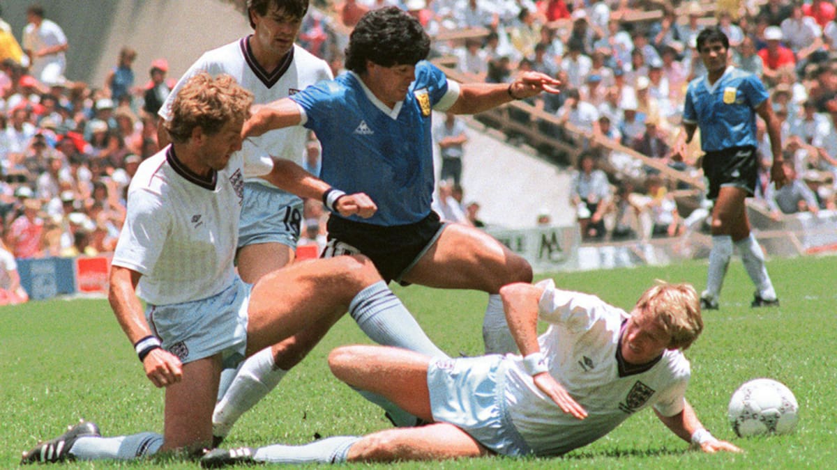 Argentinian midfielder Diego Maradona (C) dribbles past three English defenders 22 June 1986 in Mexico City during the World Cup quarterfinal soccer match between Argentina and England. Maradona scored two goals, the first one with his left hand as he jumped for the ball in front of goalkeeper Peter Shilton, as Argentina beat England 2-1. AFP PHOTO (Photo by STAFF / AFP) (Photo credit should read STAFF/AFP via Getty Images)