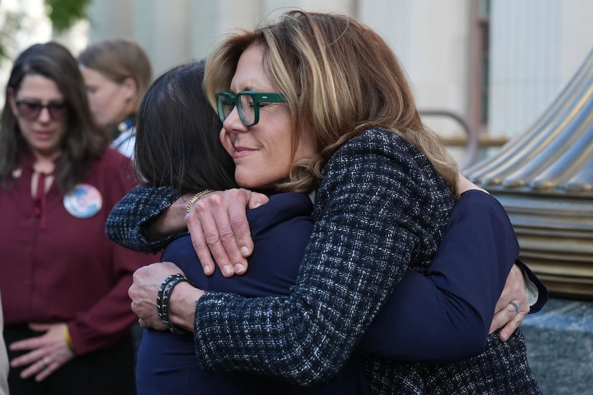 Laura Marquez-Garrett, abogada del SMVLC (Centro Legal para Victimas de Redes Sociales), abraza a Julianna Arnold, a la derecha, madre de familia, a las afueras del Tribunal Superior de Los Ångeles el jueves 12 de marzo de 2026. | Crédito: AP/Damian Dovarganes