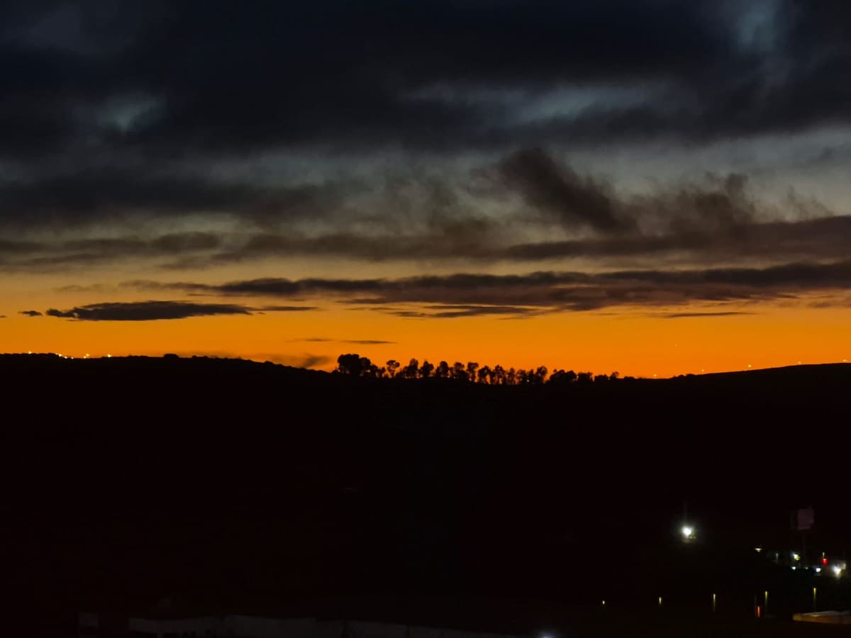 Remanentes con nubes densas en tonos grises plomizos se desplazaron hacia la costa del Pacífico, mientras una franja de luz en matices naranjas proyectó calidez visual. Foto: Sergio Ortiz