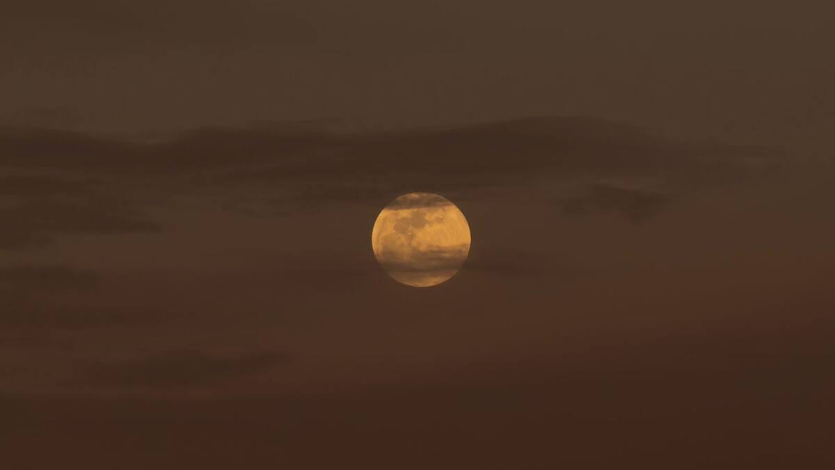 Luna de Gusano aparece entre nubes previo al eclipse lunar