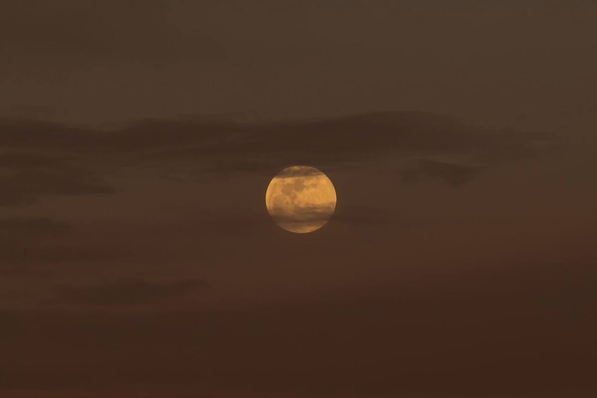 Luna de Gusano aparece entre nubes previo al eclipse lunar