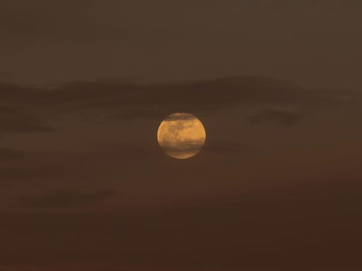 Luna de Gusano aparece entre nubes previo al eclipse lunar