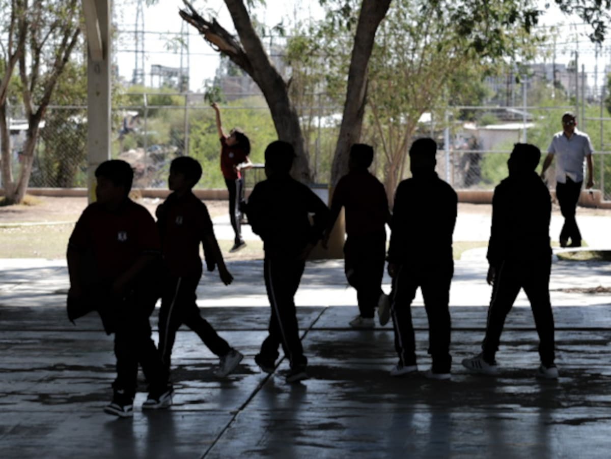 Niños juegan en el patio de una escuela.