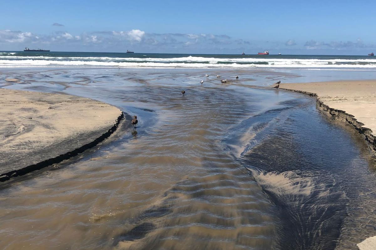Aguas negras del arroyo Huahuatay inundan playa en Rosarito
