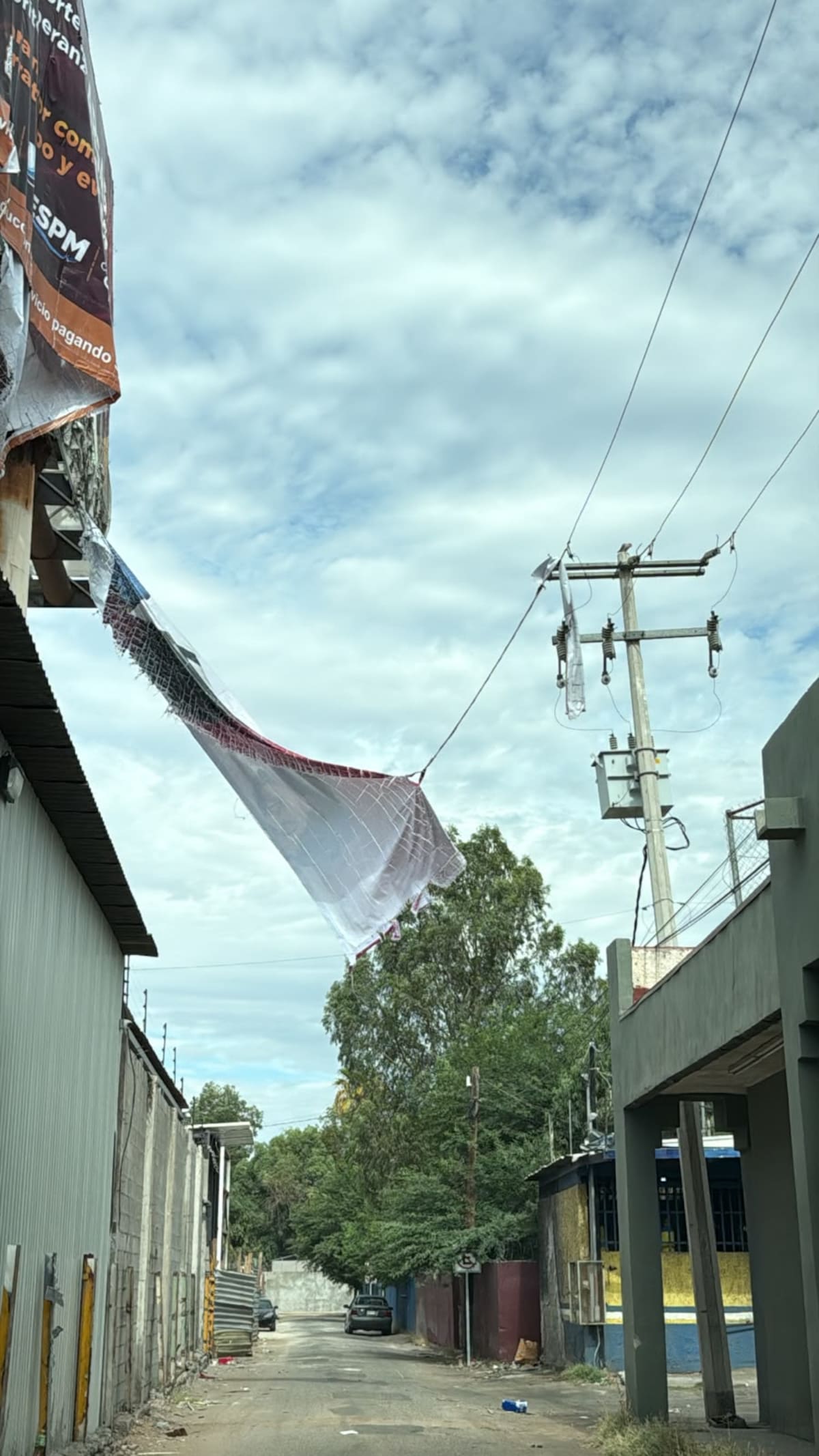 En la colonia Independencia, las ráfagas de viento derribaron una lona que cayó sobre el tendido eléctrico, ocasionando la interrupción del suministro de energía en varias viviendas. │Foto: Cortesía
